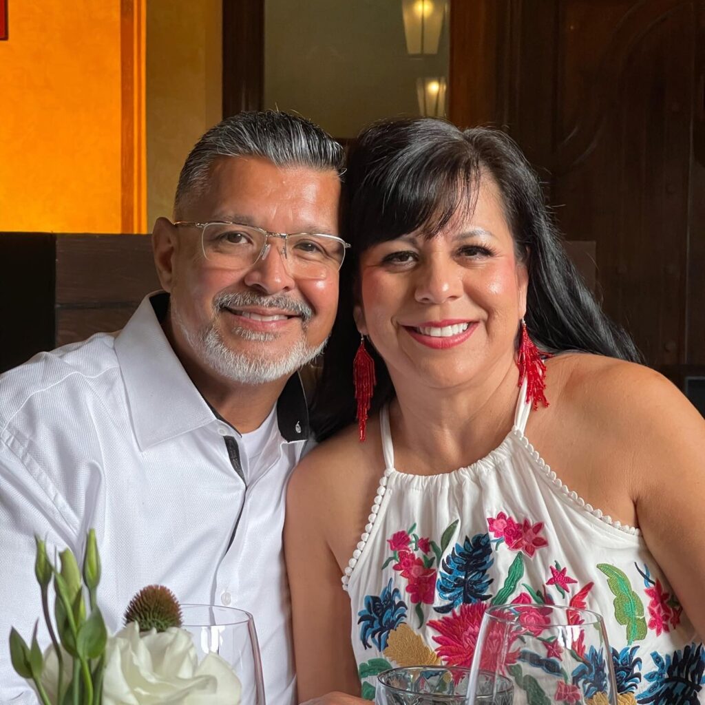 Gary and Laura, a smiling couple, sit in a warm Southern California restaurant.