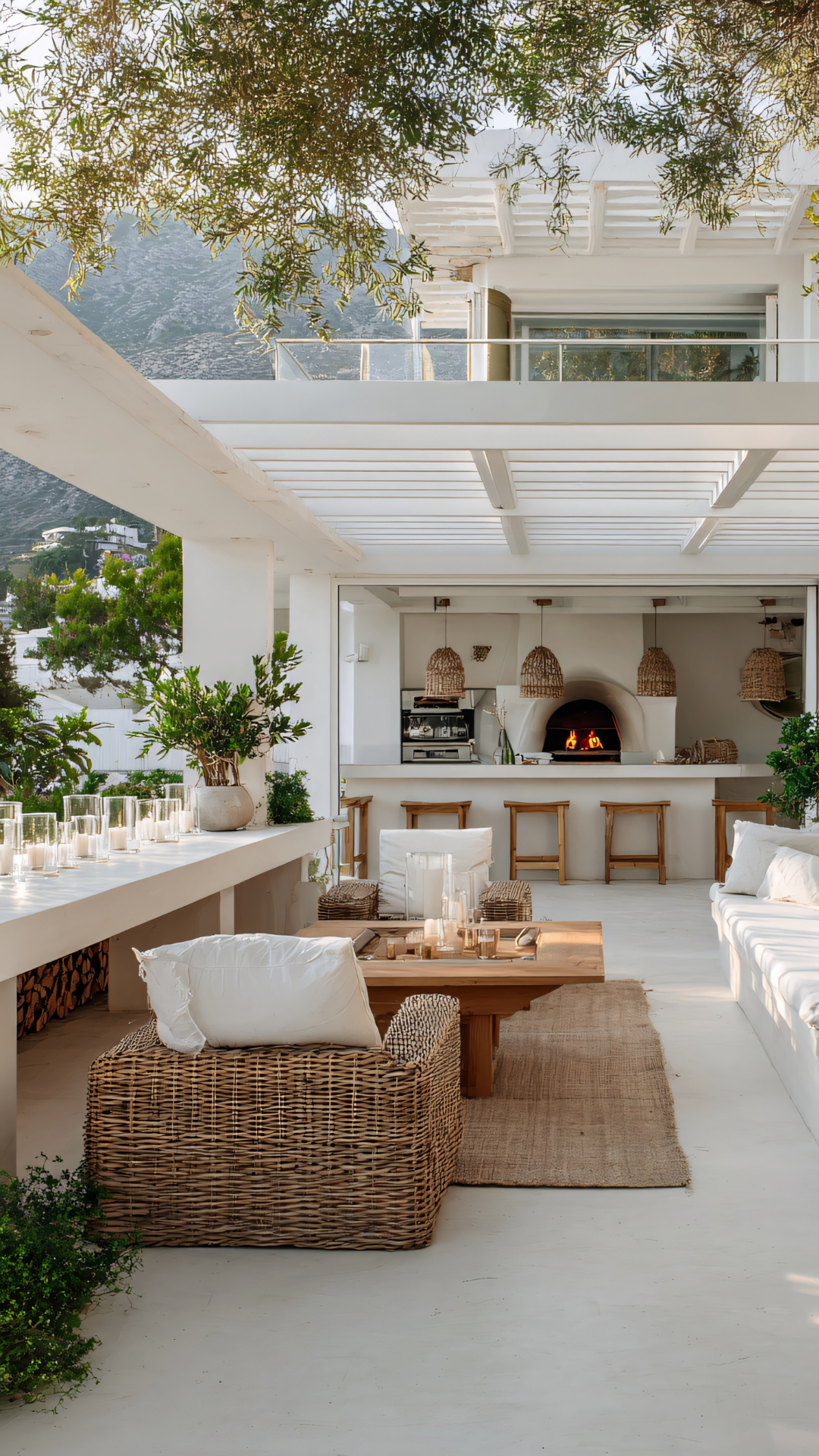 Outdoor patio in Southern California with wicker seating, a wooden table, and a view of a kitchen, surrounded by green plants.